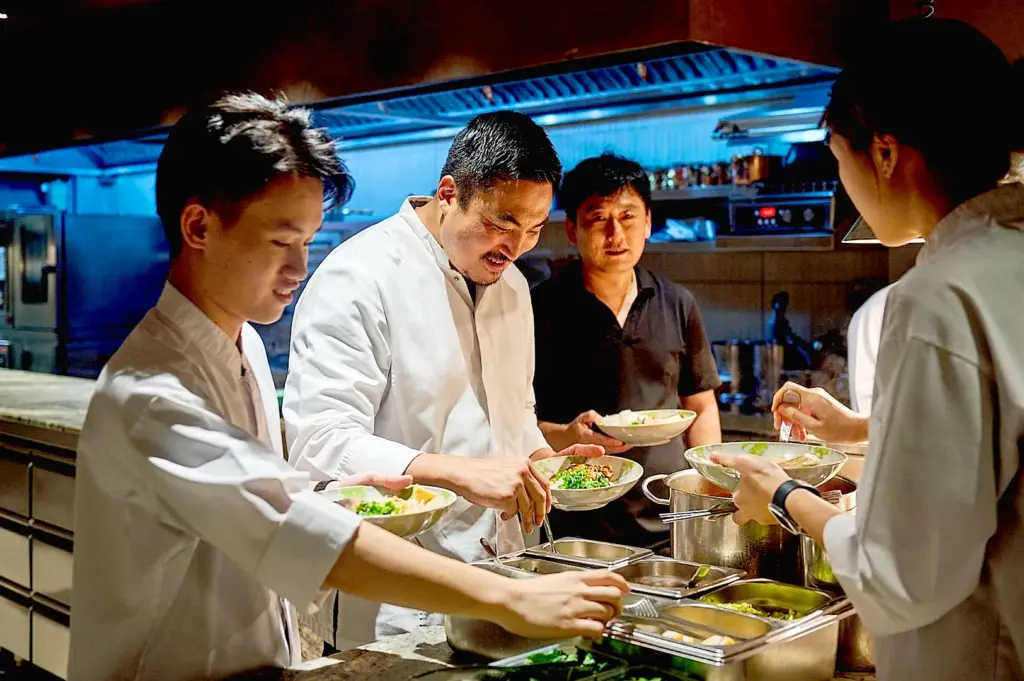 Restaurant kitchen staff eating a staff meal together.