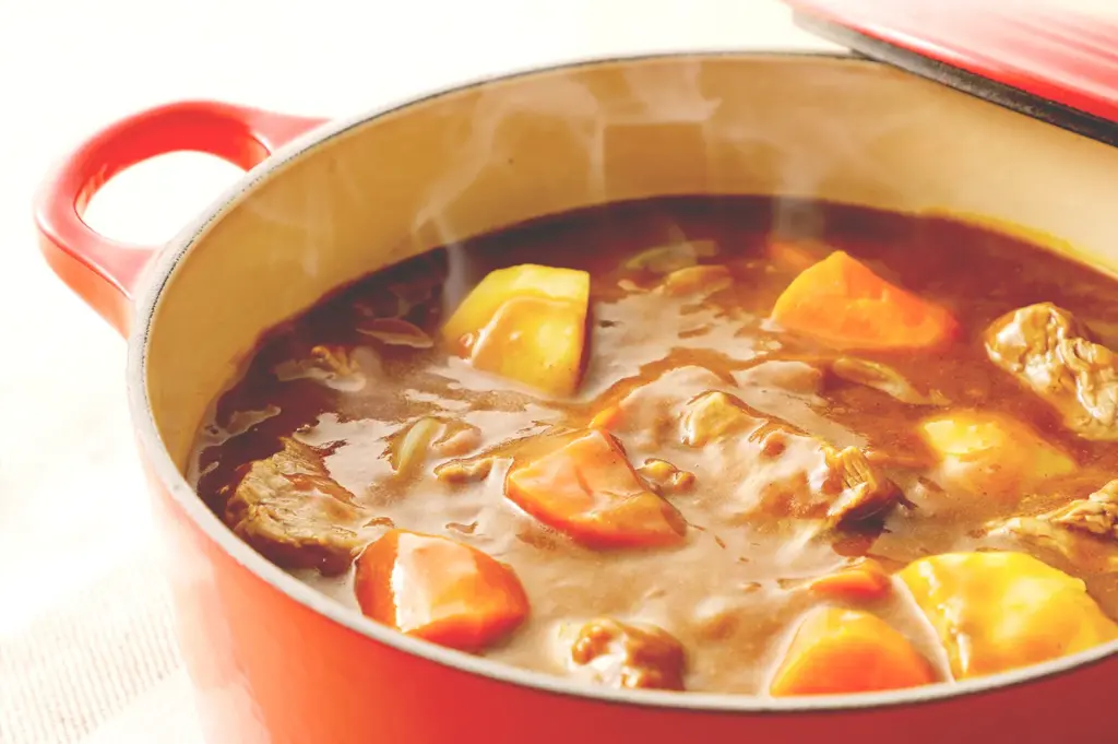 Japanese curry stew simmering with vegetables in pot.