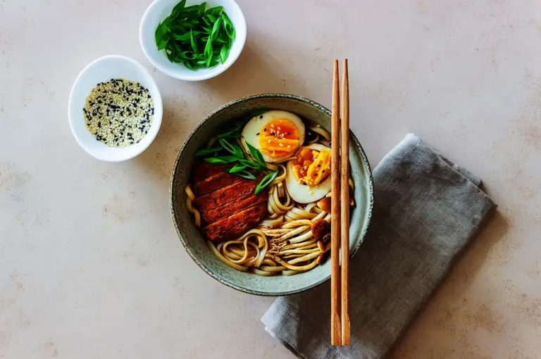 Japanese ramen bowl with noodles, soft boiled egg, and toppings arranged for a balanced meal