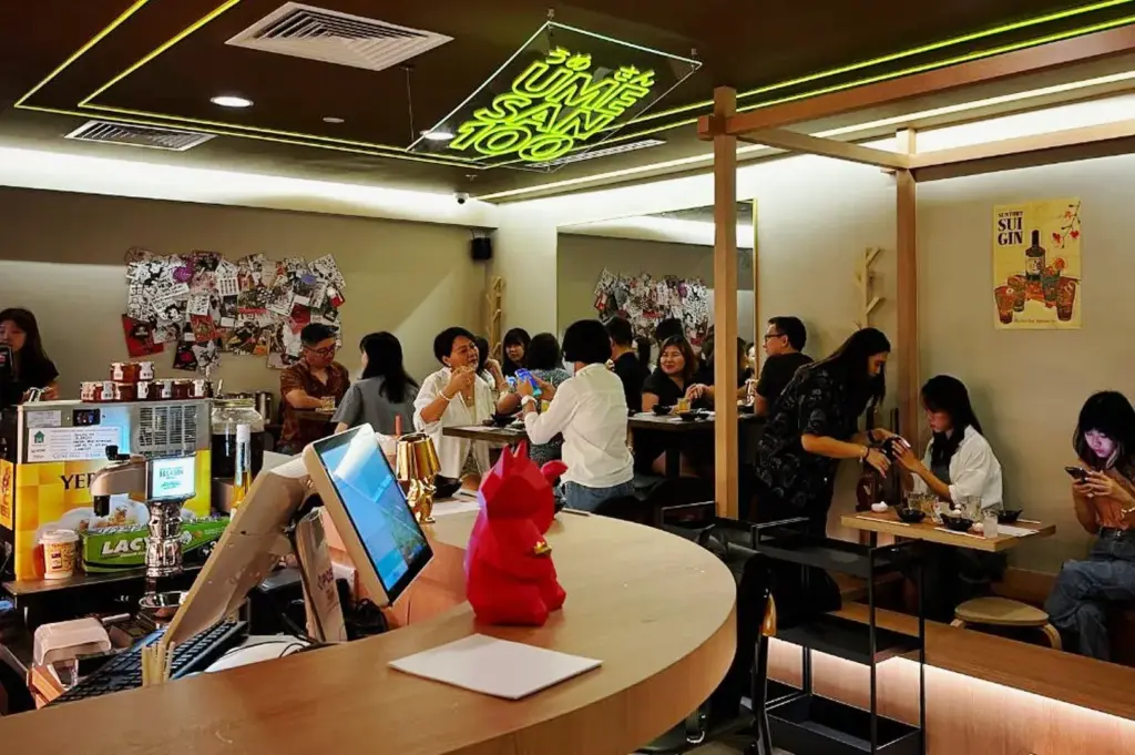 Busy ramen shop interior at Ume San 100 Singapore with diners enjoying bowls in a lively setting