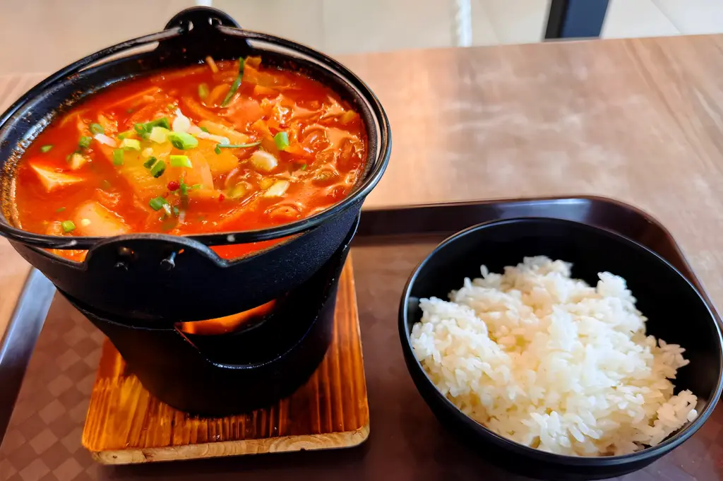 spicy ramen set in Singapore with rich red broth served alongside a bowl of white rice
