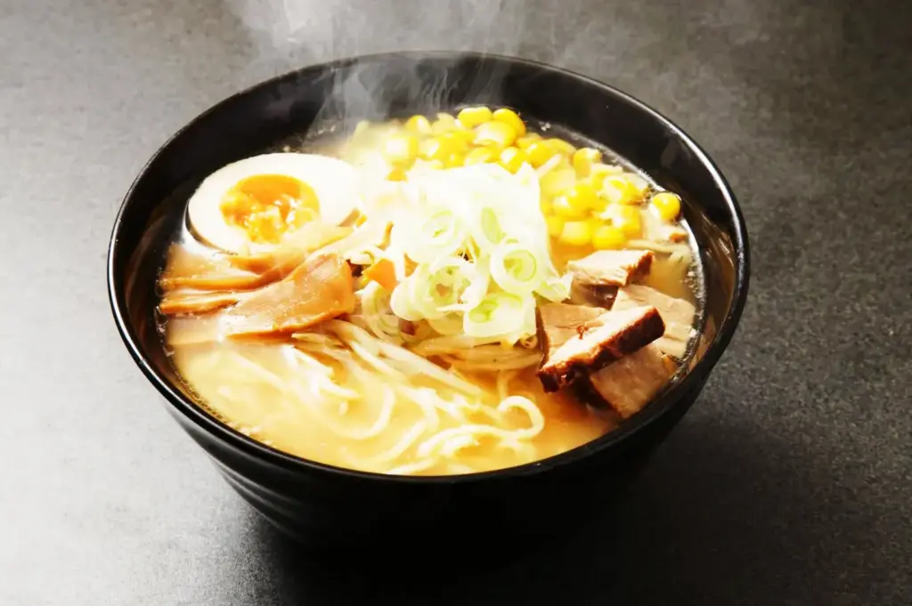 Classic tonkotsu ramen with chashu pork, egg, and corn in a steaming bowl