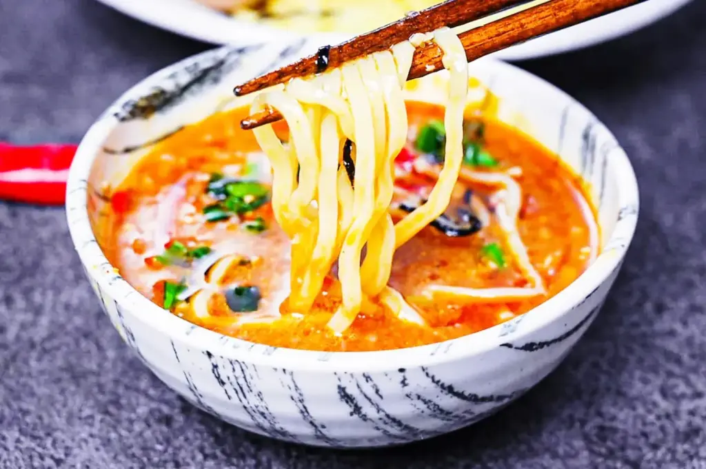 Japanese tsukemen noodles dipped in thick broth showing texture and chewiness