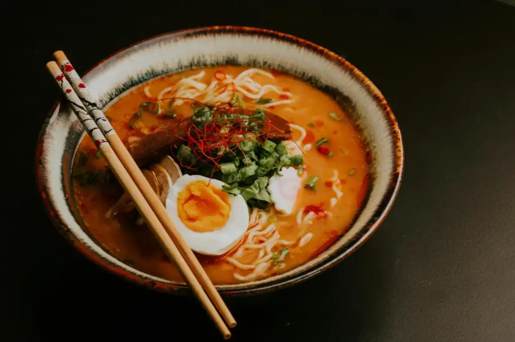 Ramen bowl with chopsticks resting on rim