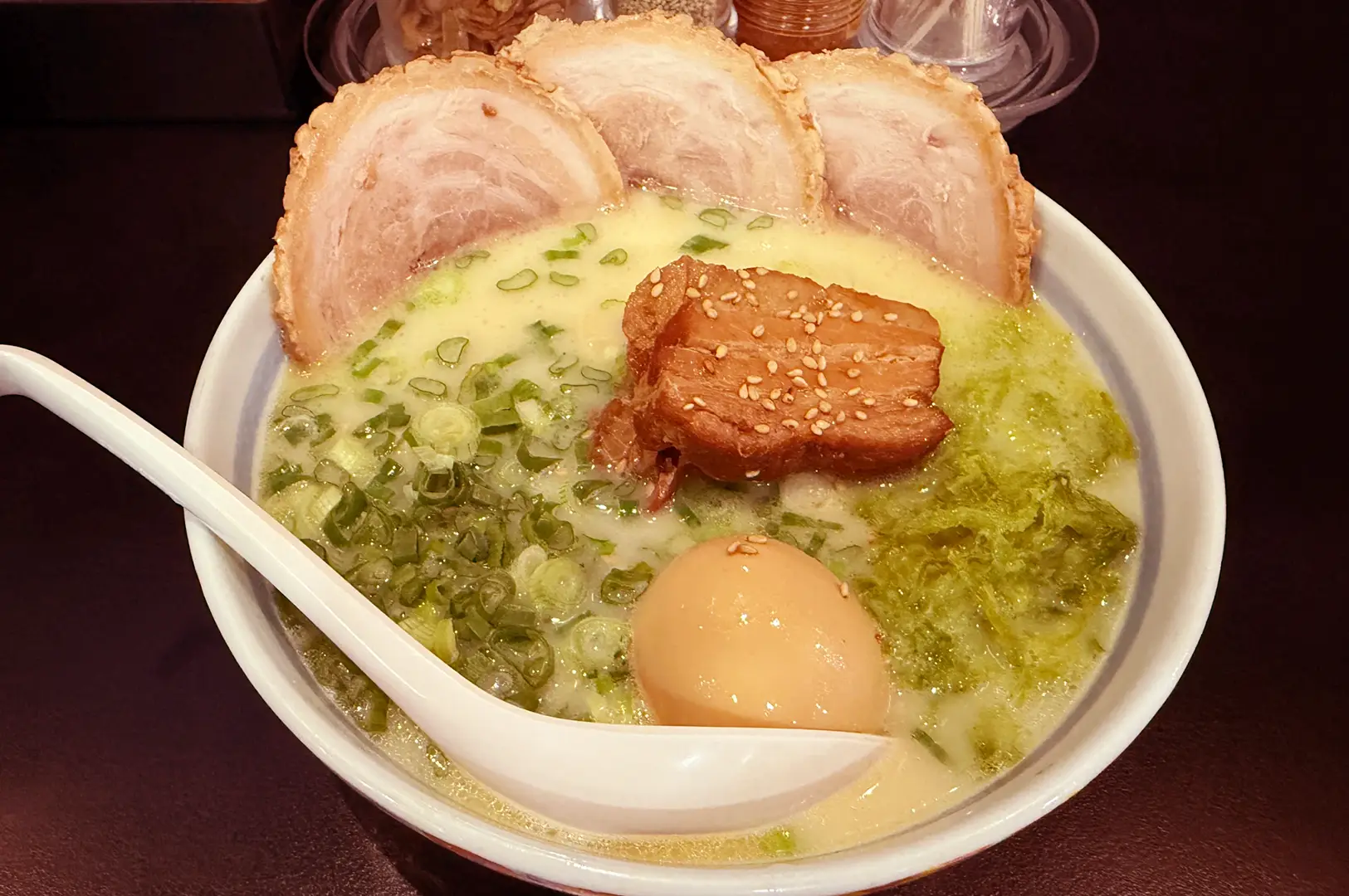 Chicken paitan ramen with chashu, soft-boiled egg, and scallions.