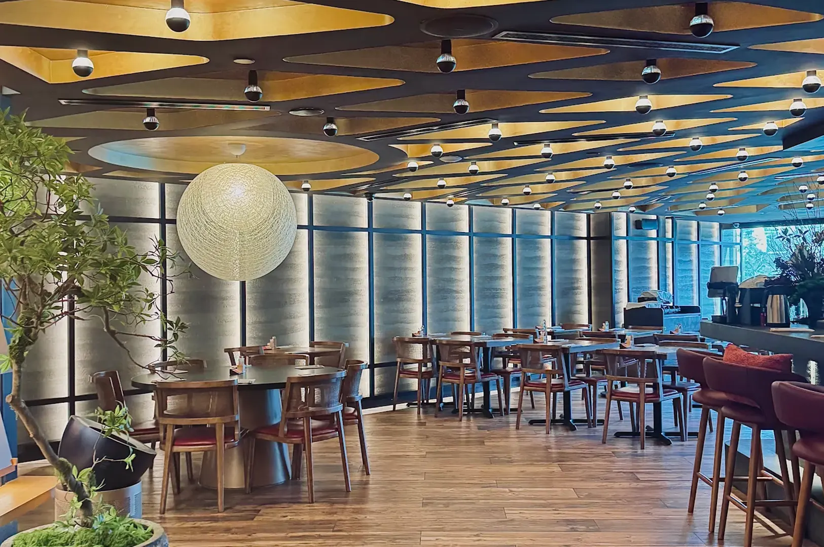Mensho dining room with circular ceiling panels and wooden tables