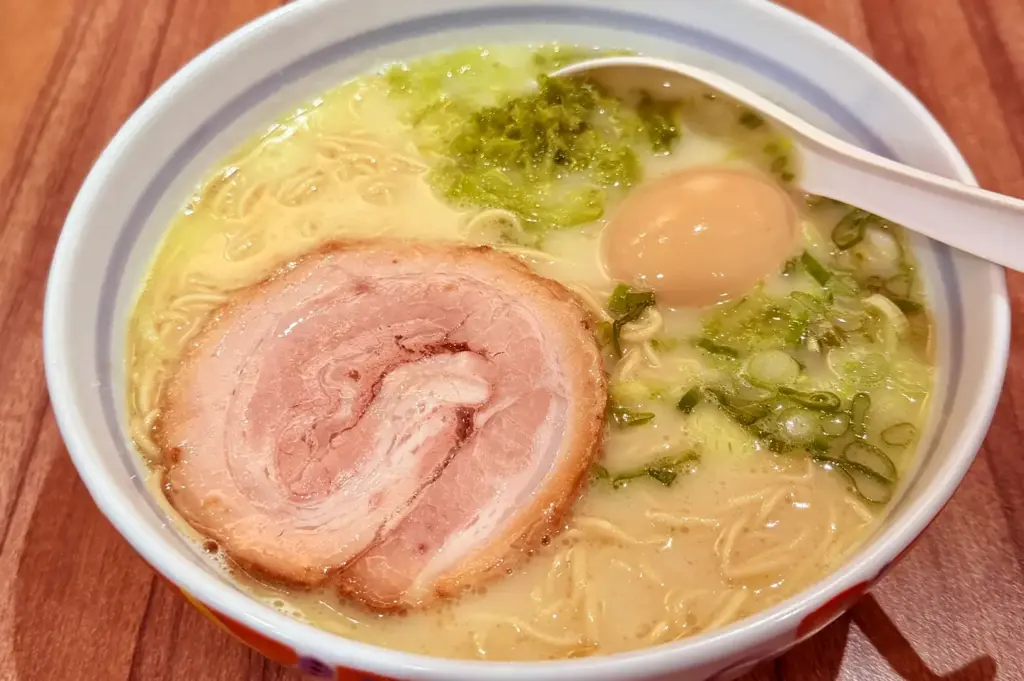 Ramen bowl with chashu pork, soft-boiled egg, and green onions.