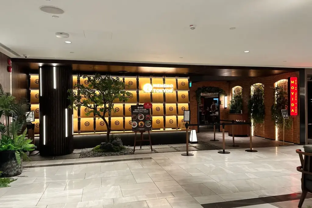 Mensho restaurant entrance with illuminated wall display and dark wood facade