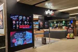 WOKE ramen restaurant interior with menu displays, counter seating, and queue barriers.