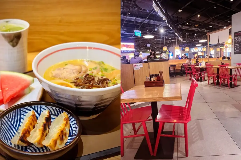 Bowl of ramen with sliced pork and green onions beside pan-fried gyoza and a slice of watermelon, next to the Ichikokudo Hokkaido Ramen dining area with wooden tables and red chairs.